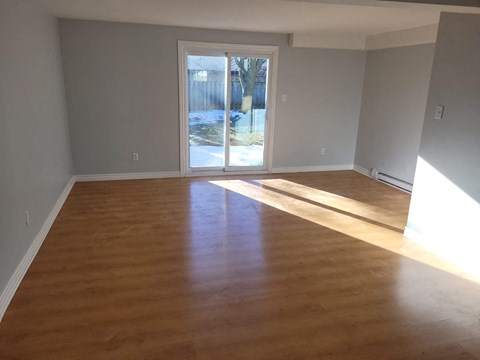 a living room with a hard wood floor and a door to a patio