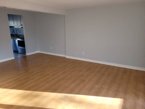 an empty living room with a wooden floor