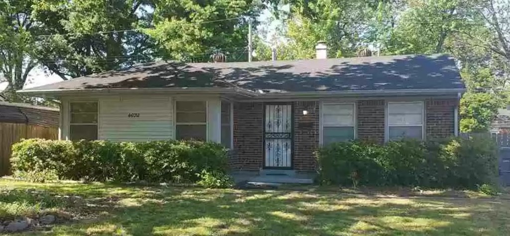 a small brick house with a blue door