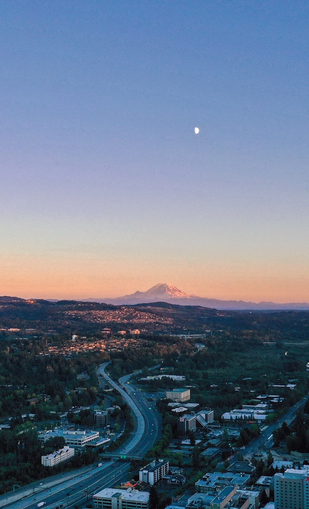the moon over mount hood at sunset with the city in the foreground
