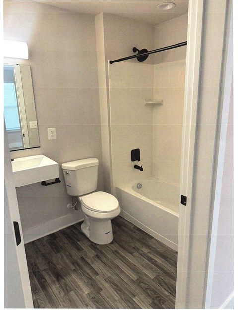 A white toilet is in a bathroom with a walk-in shower.