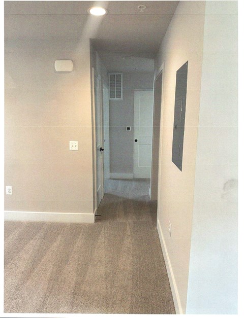 A hallway with a door at the end.