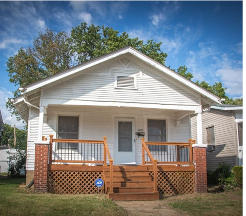 a white house with a porch and a blue sky