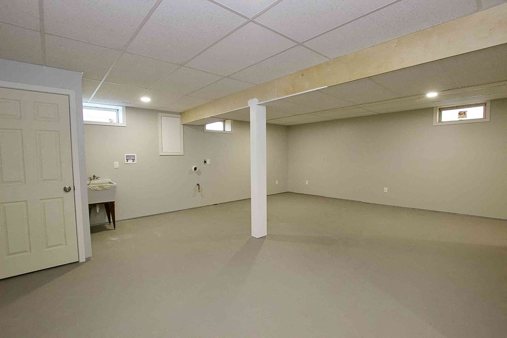 an empty room with a door and a sink in it