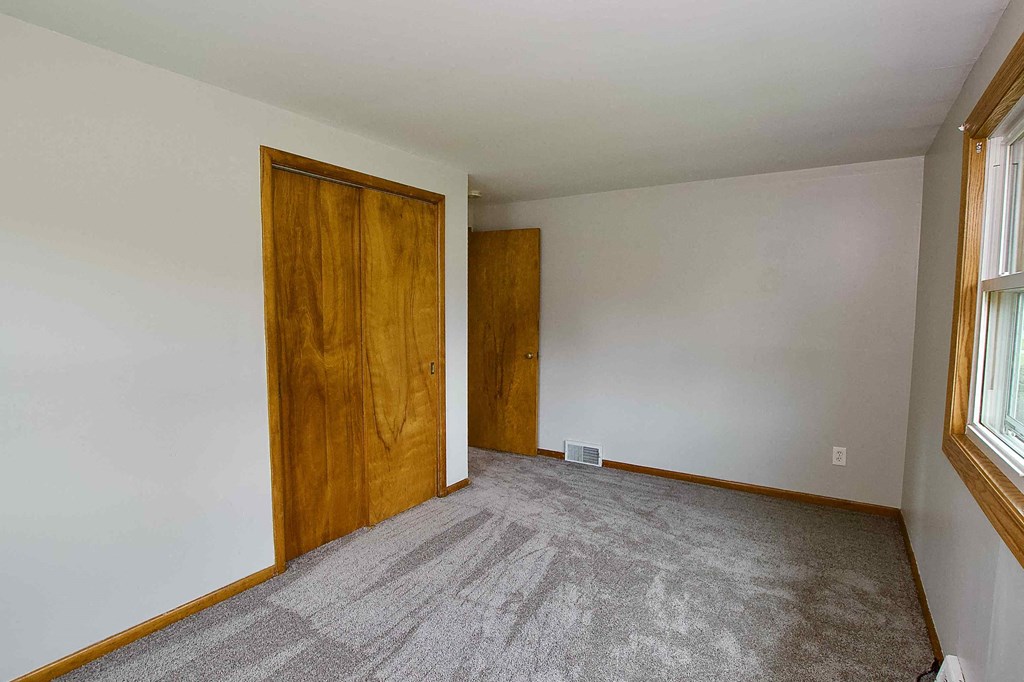a room with a carpeted floor and a wooden door