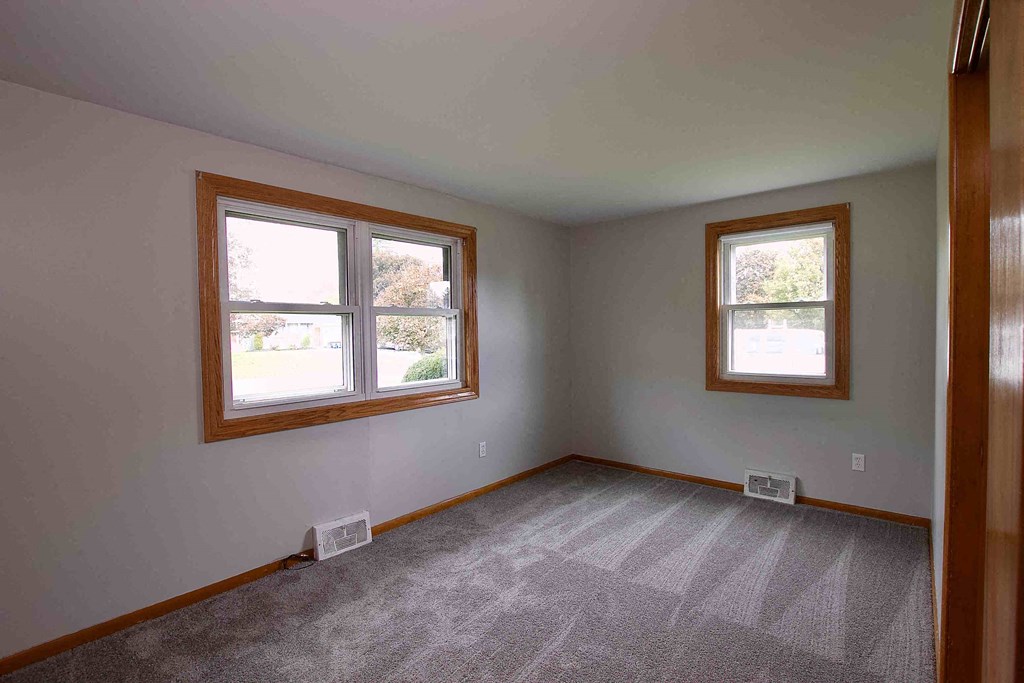 an empty room with two windows in it