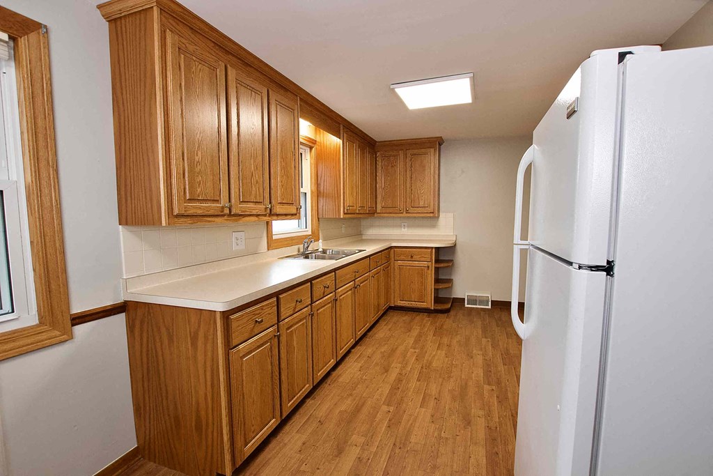 a kitchen with wooden cabinets and a white refrigerator