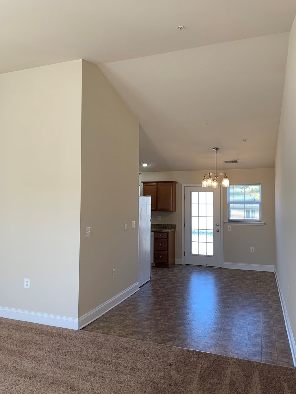 a empty living room with a kitchen in it