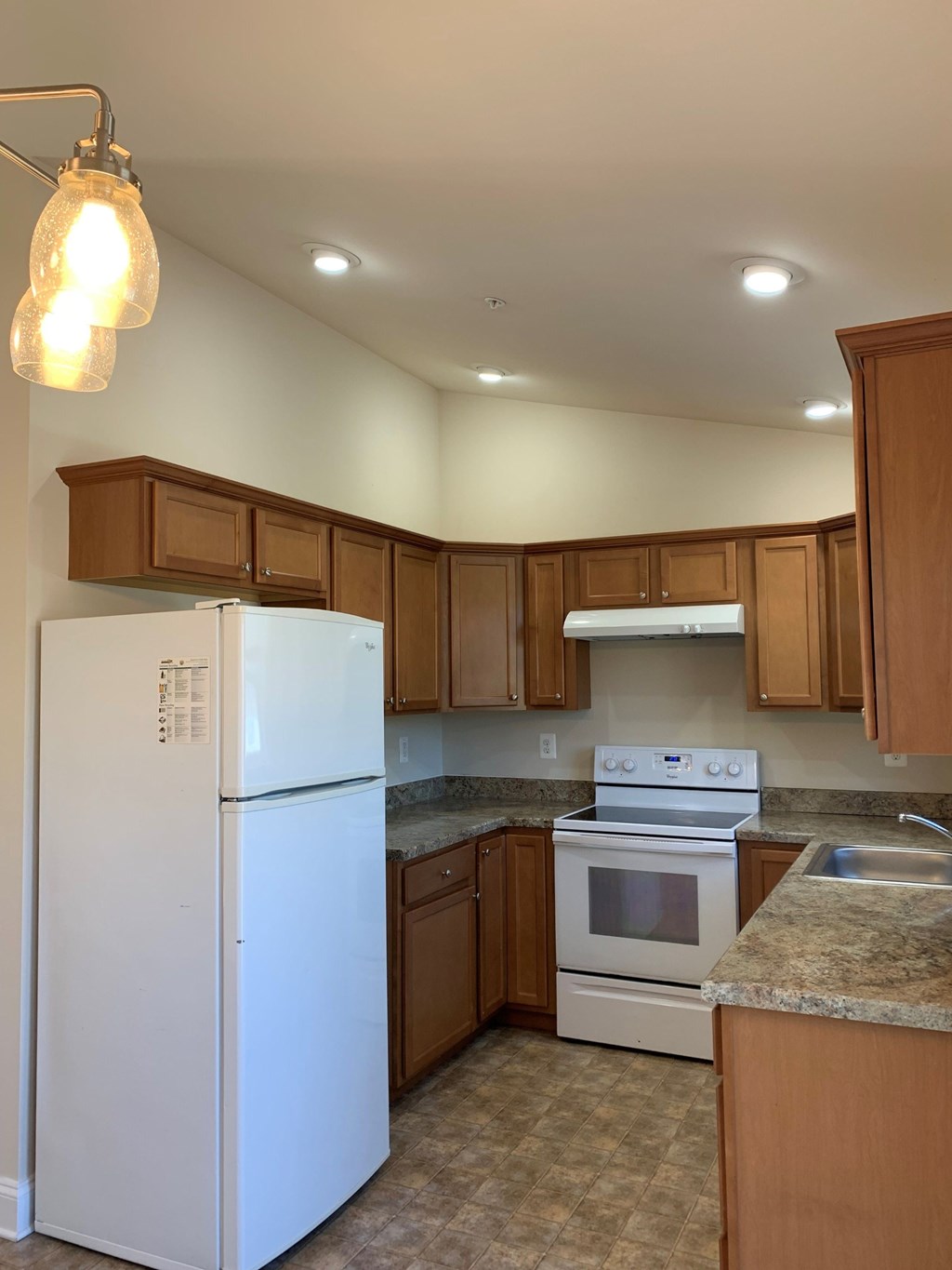 a kitchen with white appliances and wooden cabinets