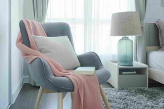 a chair with a pillow and a lamp in a room