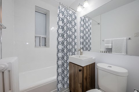 a white bathroom with a shower curtain and a sink