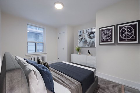 bedroom with white walls and a bed with blue blankets and pillows