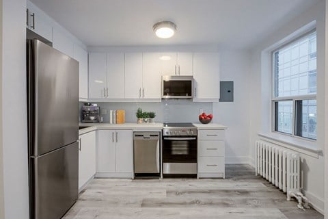 a kitchen with white cabinets and stainless steel appliances