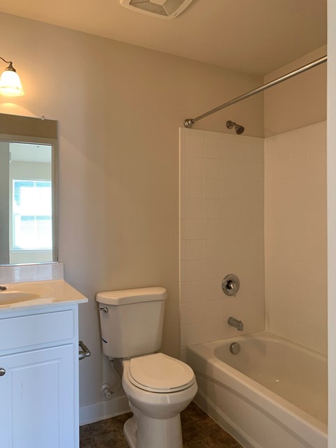 A white toilet sits next to a white sink in a bathroom.
