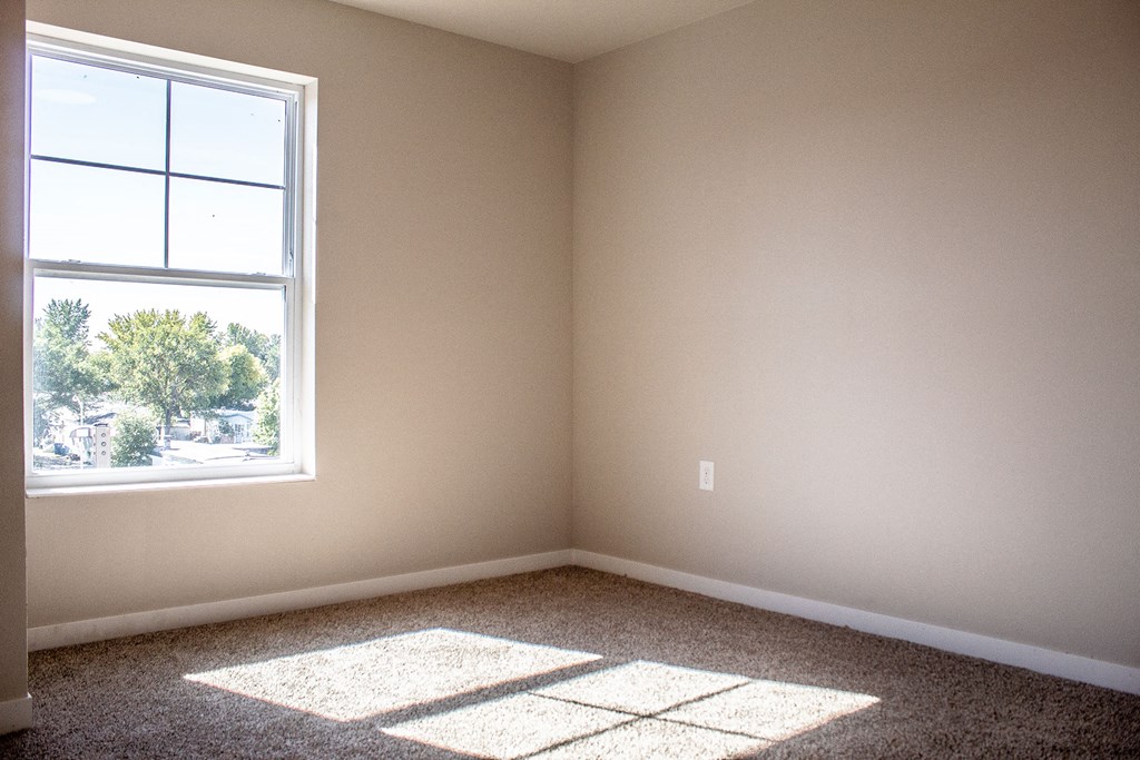 an empty room with sunlight coming through a window