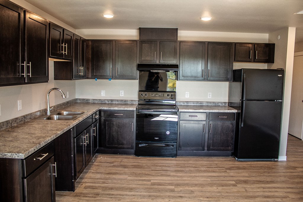 a kitchen with dark wood cabinets and stainless steel appliances
