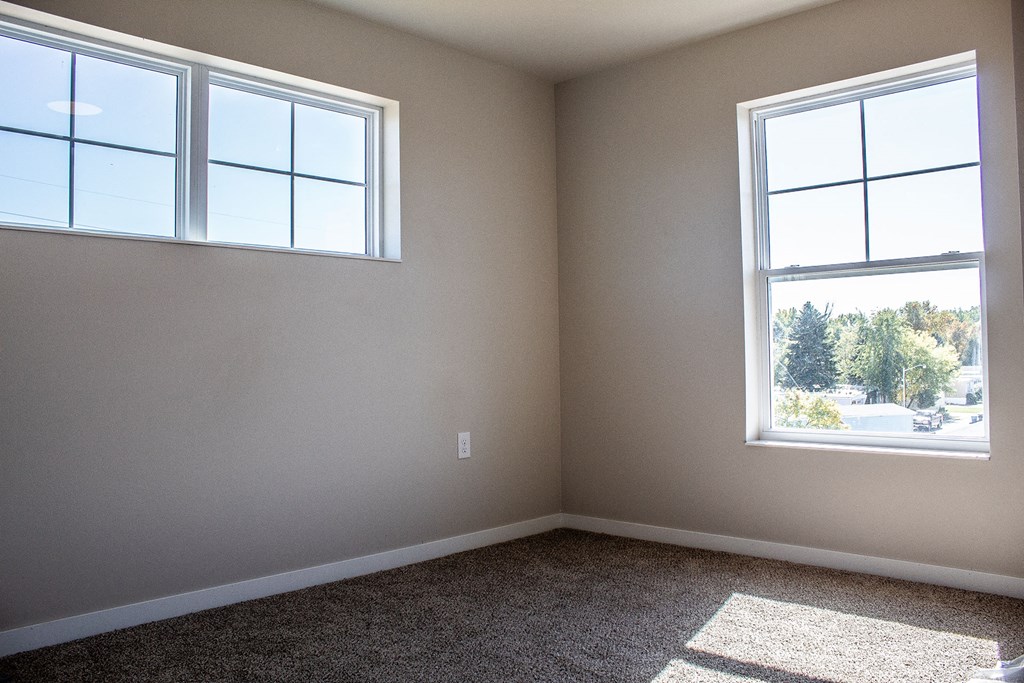an empty room with two windows in it