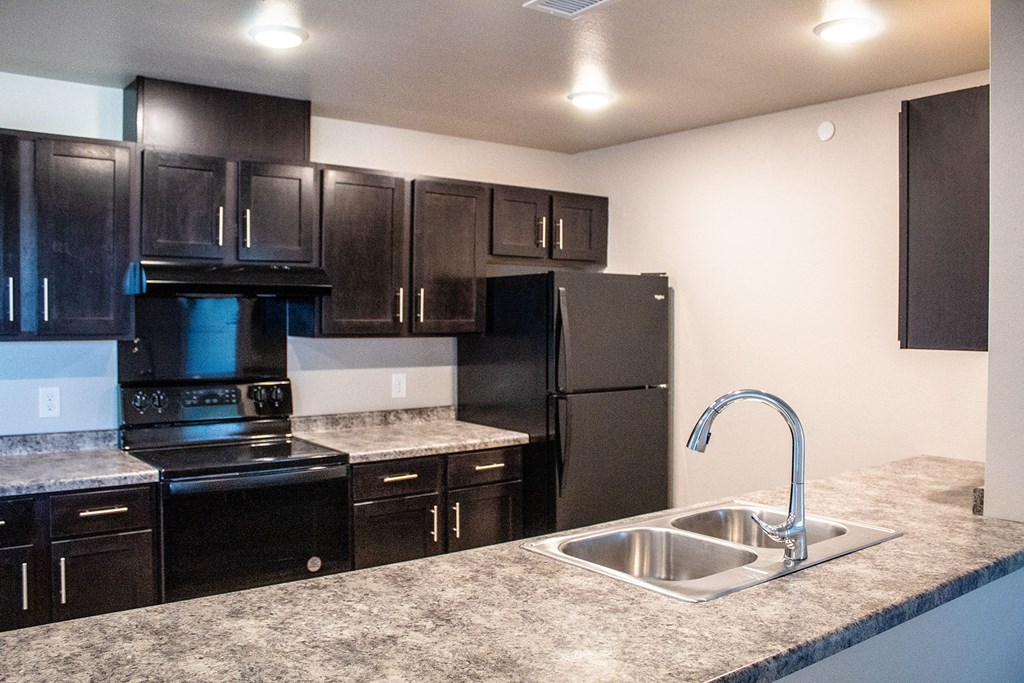 a kitchen with black appliances and granite counter tops and a sink