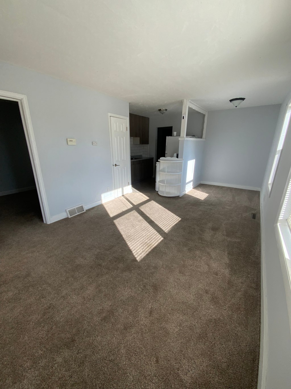 A room with a carpeted floor and a white door.