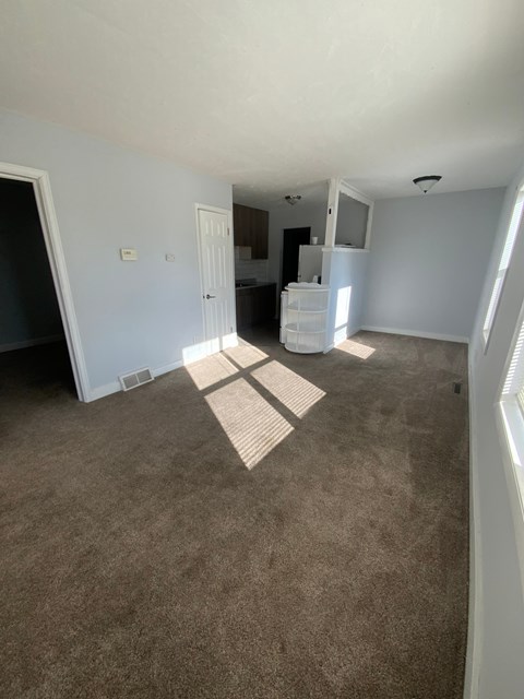 A room with a carpeted floor and a white door.