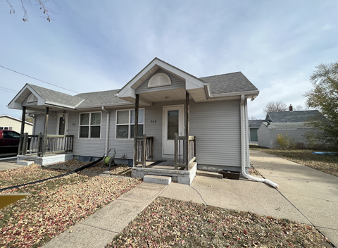 A house with a grey roof and a grey front porch.
