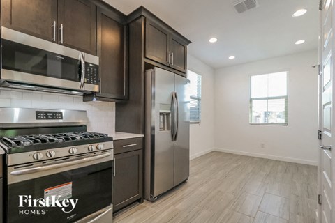 A kitchen with a stove top oven and a refrigerator.