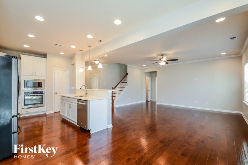 an open kitchen and living room with hardwood flooring and a kitchen island