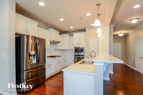 a large white kitchen with stainless steel appliances and white counter tops