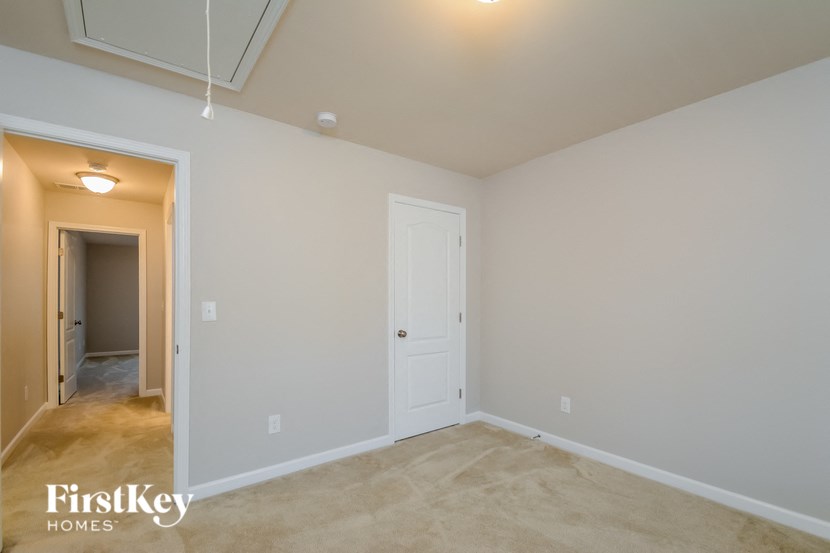 a bedroom with a closet and a door to a hallway