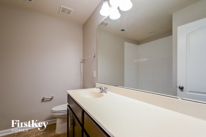 a bathroom with a large mirror and a sink and a toilet
