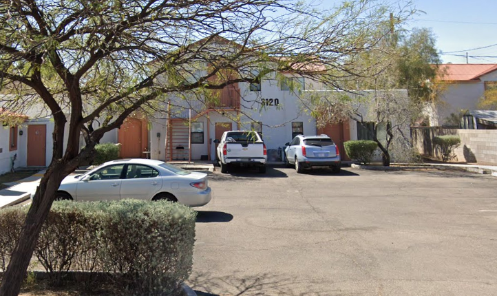 A parking lot with cars and a building with the number 3120.