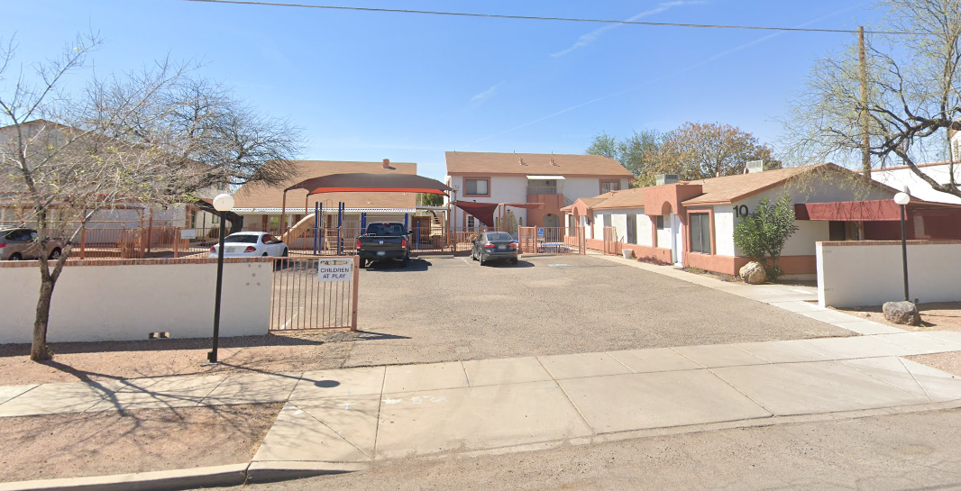 A street view of a residential area with houses and a clear sky.