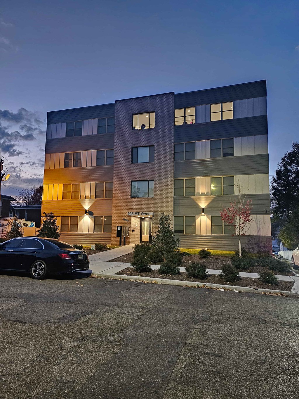 a city at night with a car parked in front of a building
