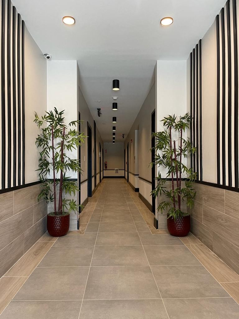 a long hallway with potted plants on the side