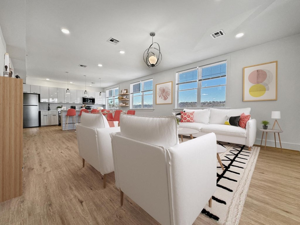 a living room and kitchen with white couches and chairs
