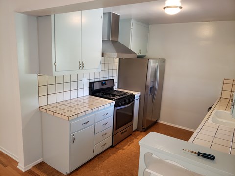 A kitchen with white cabinets and a tiled backsplash.