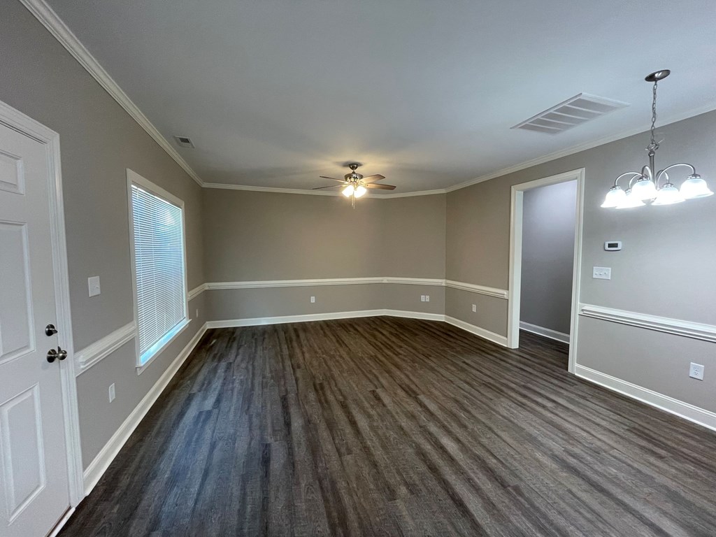 A room with a wooden floor and a ceiling fan.