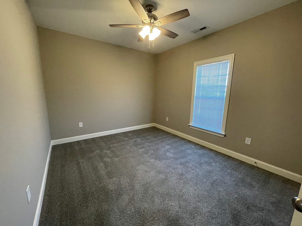 A room with a ceiling fan and a window.