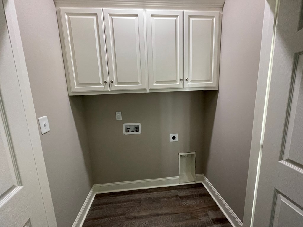 A white cabinetry is installed in a room with brown carpet.