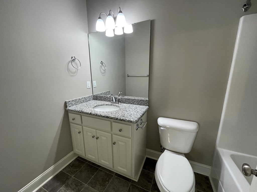 A white toilet sits next to a sink in a bathroom.