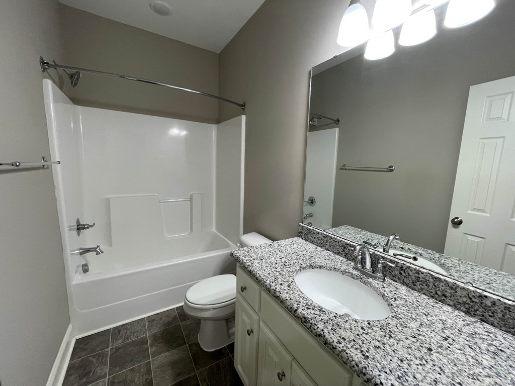 A bathroom with a toilet, sink, and bathtub.