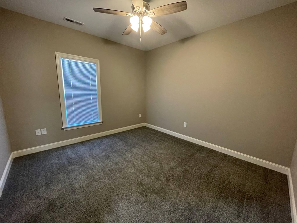 A room with a ceiling fan and a window.