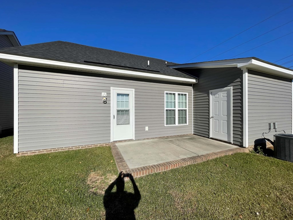 A house with a grey siding and a white door is shown.