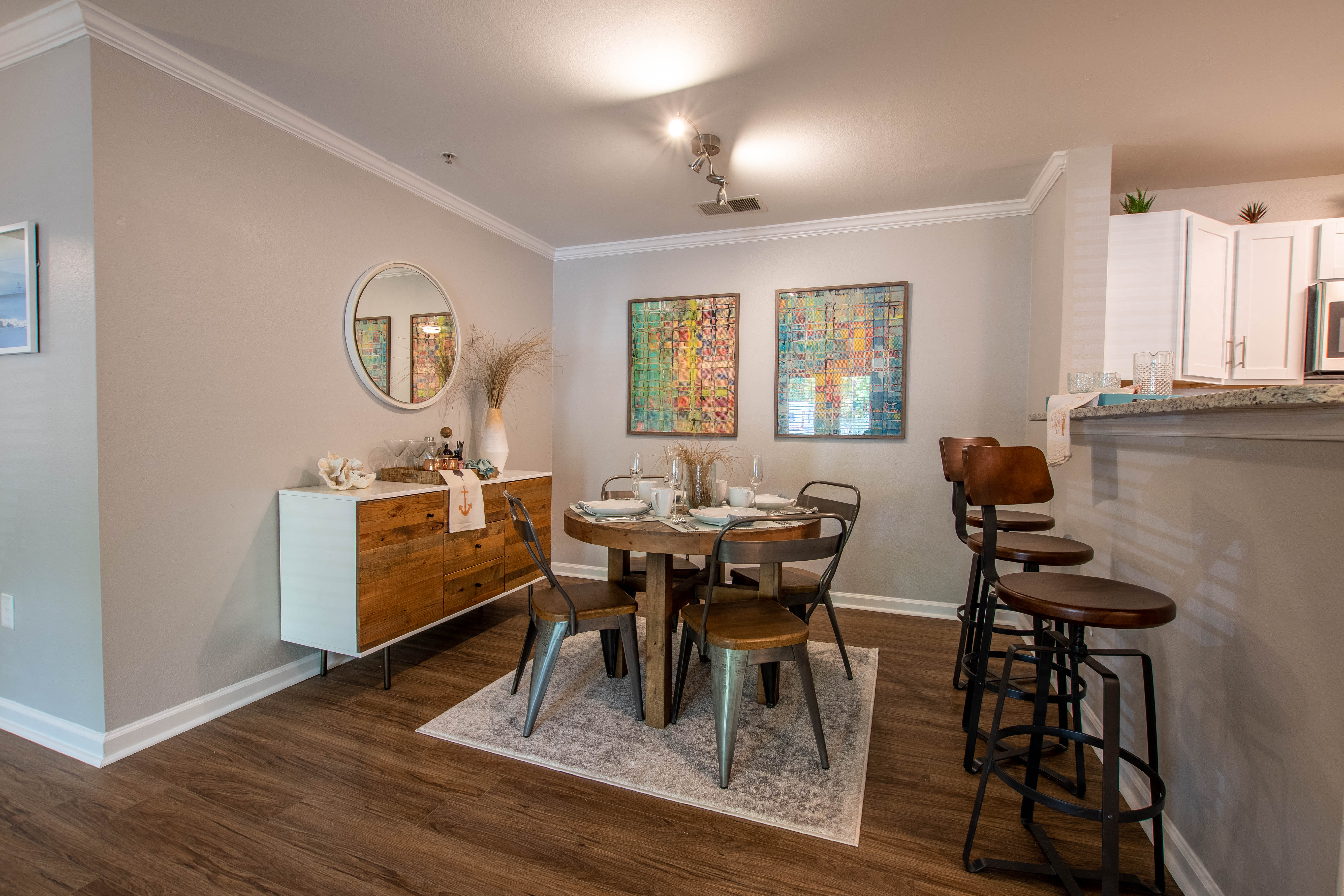 a dining room with a table and chairs and a kitchen with a bar