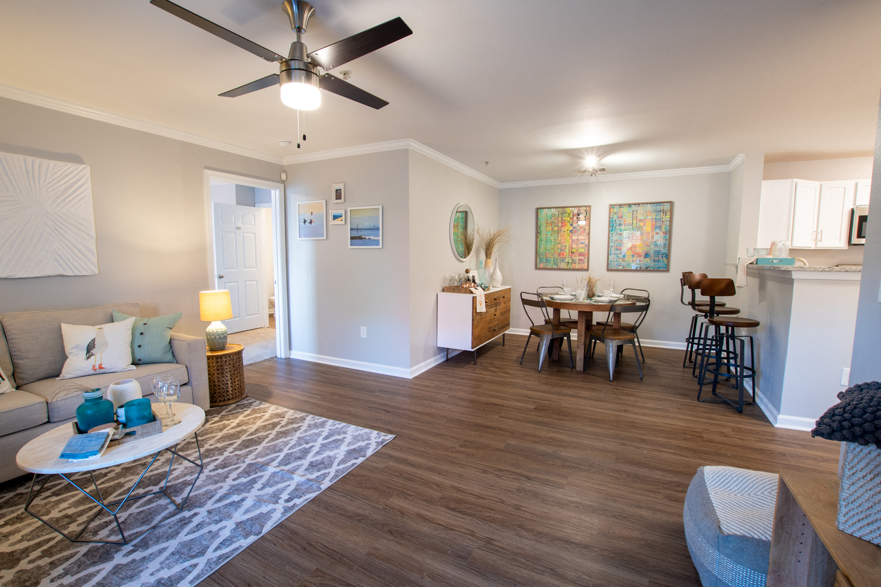 a living room and dining room with a ceiling fan