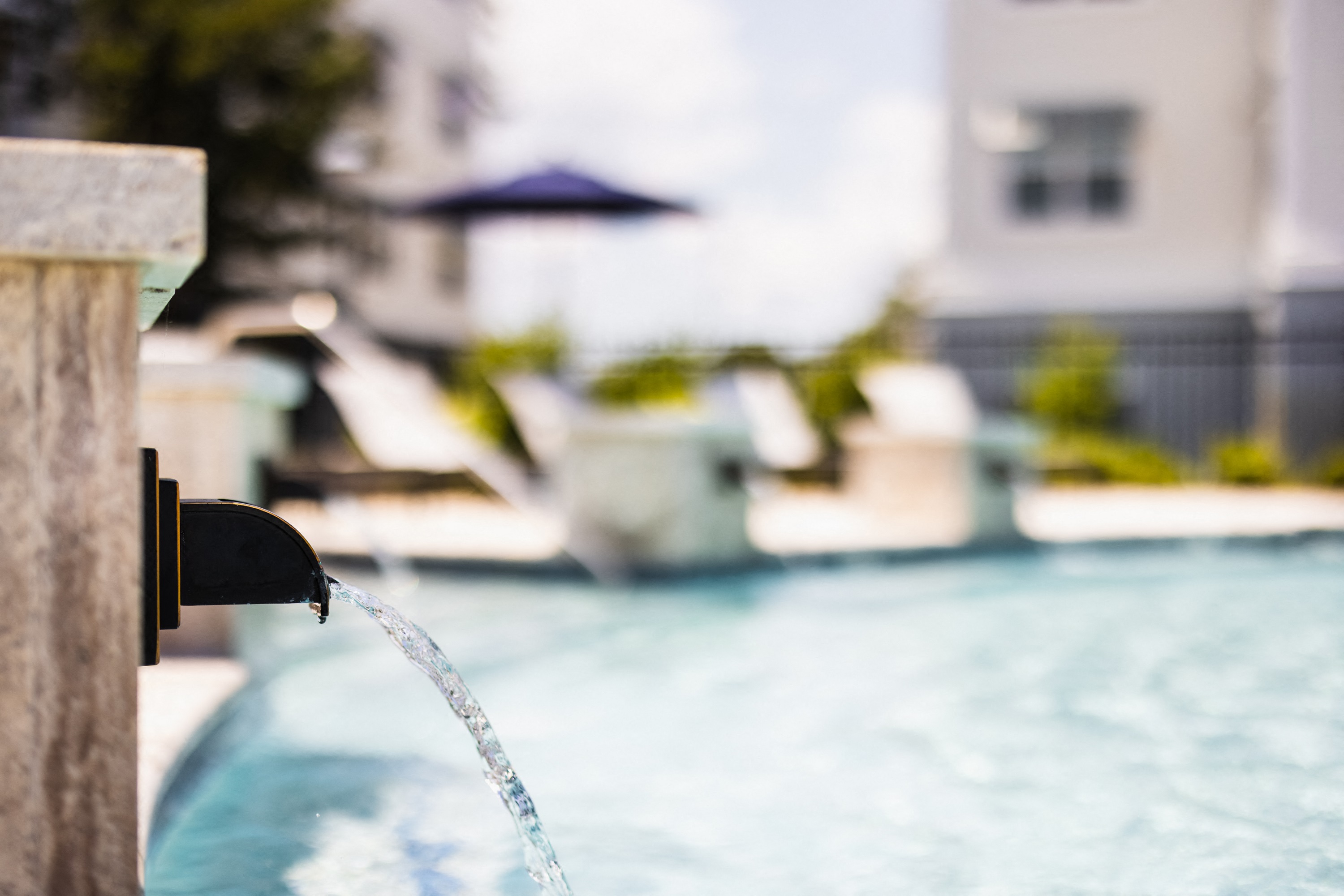 a water faucet spraying water into a pool