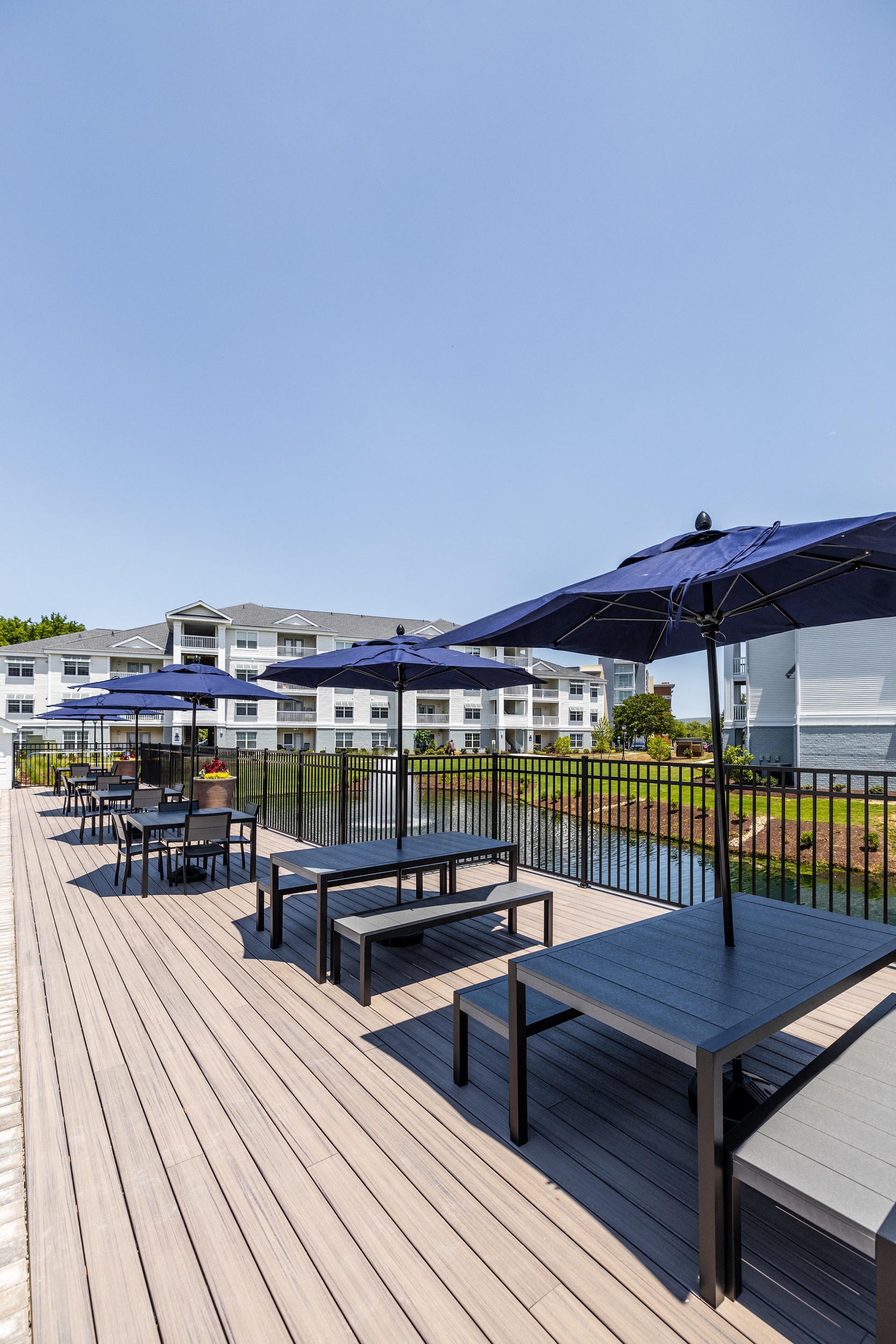 an outdoor patio with tables and umbrellas on a sunny day