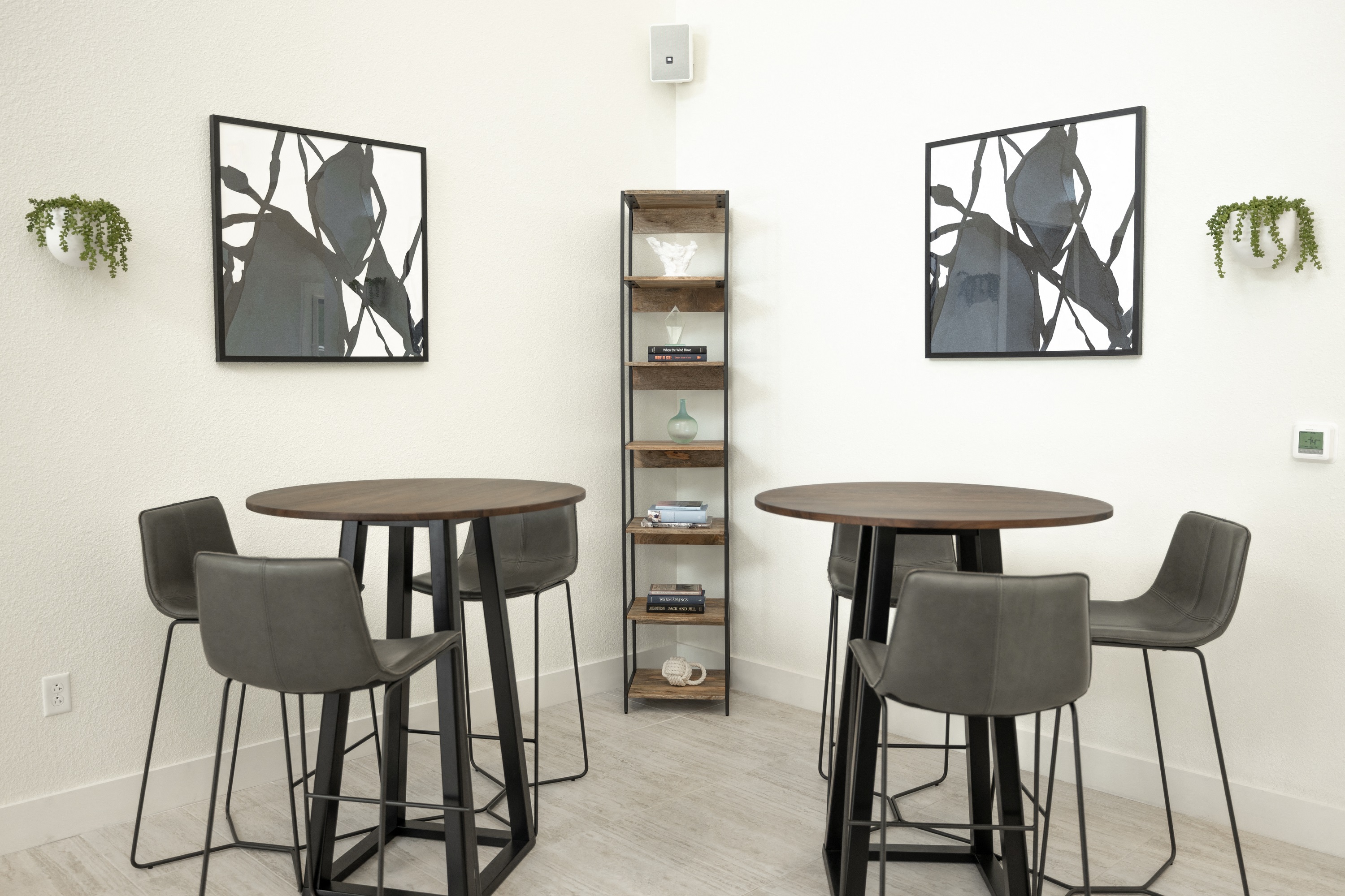 three tables and chairs in a room with paintings on the wall