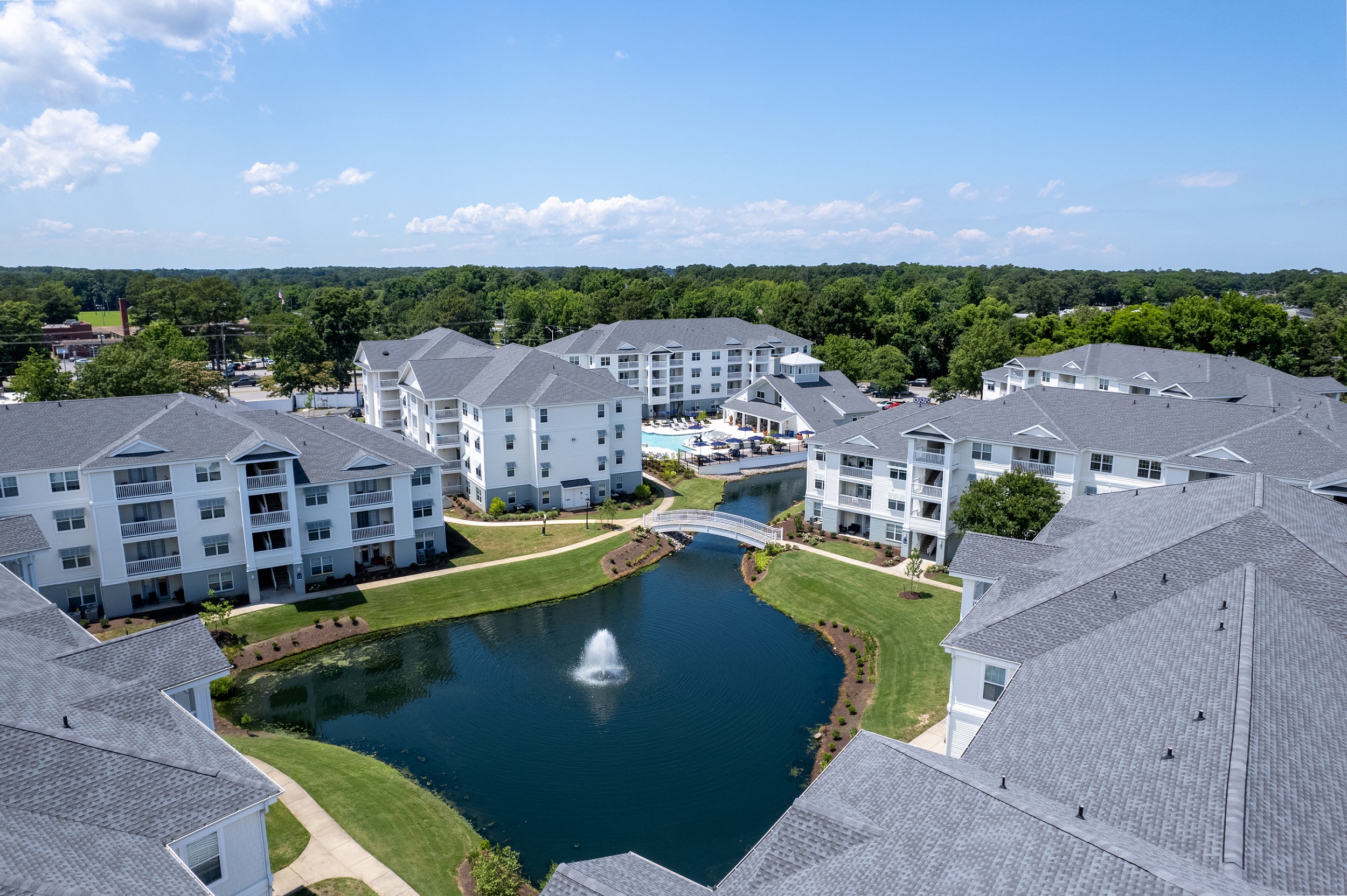 an aerial view of an apartment complex with a pond