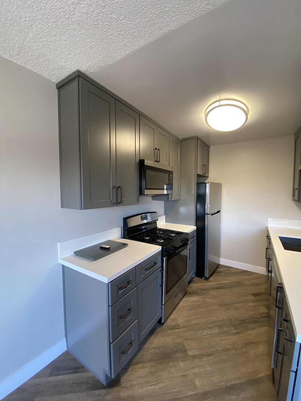 a kitchen with stainless steel appliances and gray cabinets